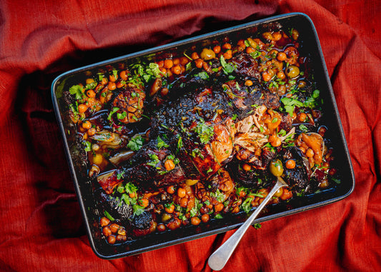 slow cooked lamb shoulder with peaches and chickpeas in dish